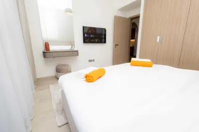 a bedroom with a bed with two yellow towels on it at Burj Khalifa View Pool Gym 10 Min To Downtown in Dubai