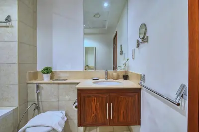 a bathroom with a sink and a toilet and a mirror at GuestReady - Charming stay with Burj Khalifa views in Dubai