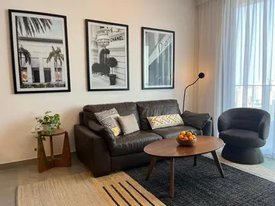 a living room with a leather couch and a table at Dubai Marina stunning views holiday apartment Stella Maris Tower in Dubai