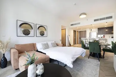 a living room with a couch and a bed at Chic 2 Bed Near Trade Centre with 5 Star Amenities in Dubai