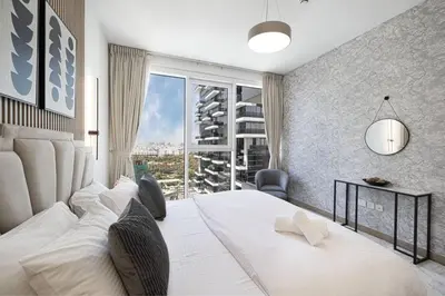 a bedroom with a white bed and a large window at Chic 2 Bed Near Trade Centre with 5 Star Amenities in Dubai