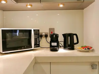 a microwave sitting on top of a kitchen counter at Spacious 4BR Duplex with Terrace - JBR in Dubai
