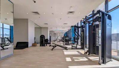 a gym with cardio equipment in a building at Chic Studio in Azizi Riviera 46, Al Merkadh by Deluxe Holiday Homes in Dubai