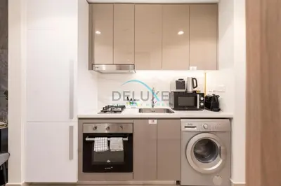 a kitchen with a sink and a washing machine at Chic Studio in Azizi Riviera 46, Al Merkadh by Deluxe Holiday Homes in Dubai