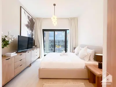 a white bedroom with a large bed and a television at Elegant Stay in Meydan Balcony & Stunning Views in Dubai