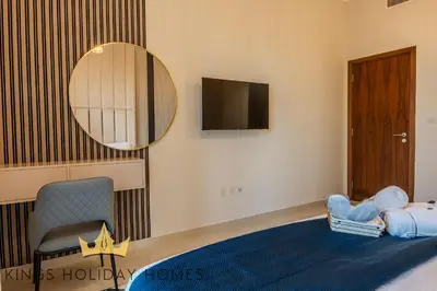 a bedroom with a mirror and a chair and a bed at Luxury Apartments Dunya tower Burj Khalifa St kings in Dubai