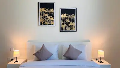 a bedroom with a white bed with two pictures on the wall at Sunday Sheikh Zayed Road Concord Tower 2 BR by Belvilla in Dubai