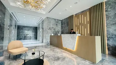 a man standing at a counter in a lobby at Sunday Sheikh Zayed Road Concord Tower 2 BR by Belvilla in Dubai