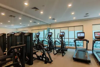 a gym with several tread machines in a room at Stylish 1-BR Oasis Minutes from Burj & Dubai Mall in Dubai