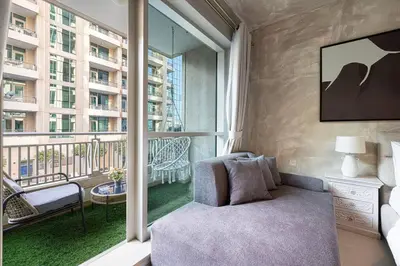 a living room with a couch and a large window at Stylish 1-BR Oasis Minutes from Burj & Dubai Mall in Dubai