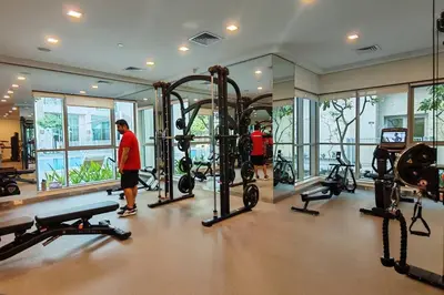 a gym with several tread machines and two people in it at Stylish 1-BR Oasis Minutes from Burj & Dubai Mall in Dubai