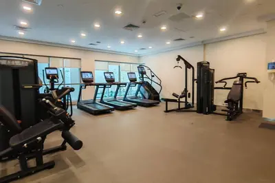 a gym with several treadmills and cardio machines at Stylish 1-BR Oasis Minutes from Burj & Dubai Mall in Dubai