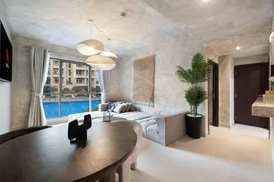 a living room with a table and a couch at Stylish 1-BR Oasis Minutes from Burj & Dubai Mall in Dubai