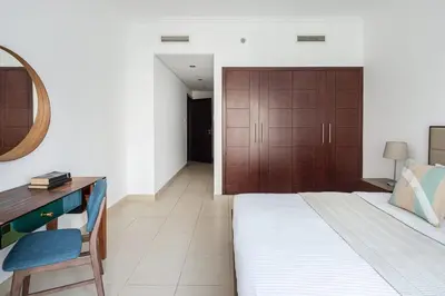 a bedroom with a bed and a desk and a mirror at Frank Porter - Burj Views West in Dubai