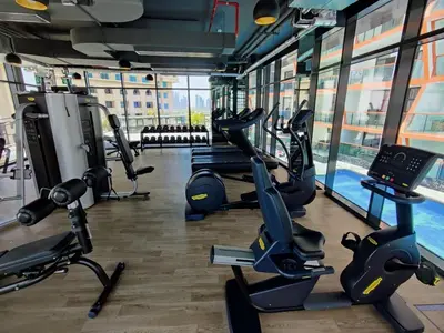 a gym with cardio machines and a swimming pool at Close to burj khalifa nice place in Dubai