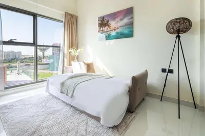 a white bedroom with a bed and a large window at Frank Porter - Wavez Residence in Dubai