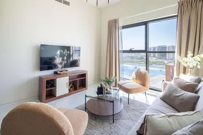 a living room with a couch and a tv at Frank Porter - Wavez Residence in Dubai