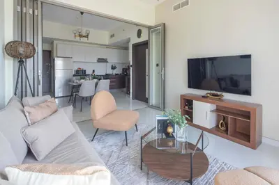 a living room with a couch and a tv at Frank Porter - Wavez Residence in Dubai