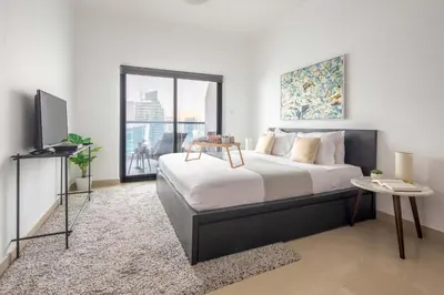 a bedroom with a large bed and a television at Frank Porter - Time Place Tower in Dubai