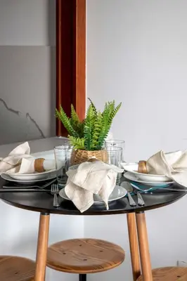 a black table with plates and a plant on it at Frank Porter - Time Place Tower in Dubai