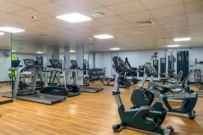 a gym with several treadmills and exercise bikes at Frank Porter - Time Place Tower in Dubai