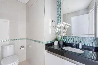 a bathroom with a sink and a toilet and a mirror at Frank Porter - Damac Heights in Dubai