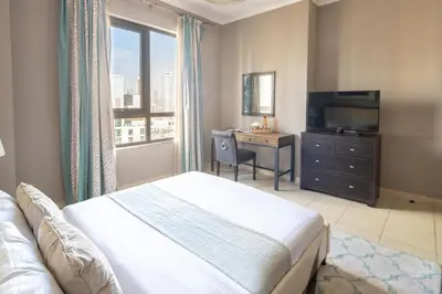 a bedroom with a bed and a desk and a television at Frank Porter - The Residences Tower 8 in Dubai