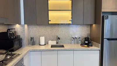 a kitchen with a sink and a counter top at Guest Favorite 1BR Designer Apt with Beach Access by Vibel in Dubai