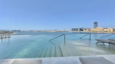 a swimming pool with a view of a body of water at Guest Favorite 1BR Designer Apt with Beach Access by Vibel in Dubai
