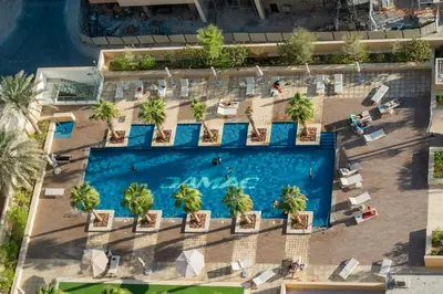 an overhead view of a swimming pool with chairs and people at Quirky Studio Apartment in Damac Ghalia in Dubai
