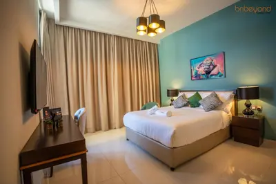 a bedroom with a bed and a desk in a room at Quirky Studio Apartment in Damac Ghalia in Dubai