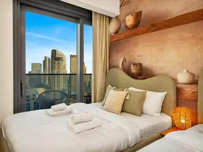 a bedroom with two beds and a large window at Wabi-Sabi Style Fountain-View 4 BR Apt in the Sky in Dubai
