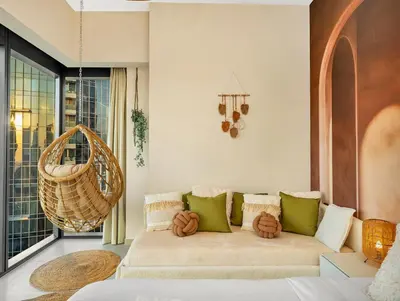 a living room with a couch and a large window at Wabi-Sabi Style Fountain-View 4 BR Apt in the Sky in Dubai