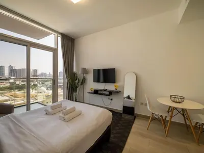 a hotel room with a large bed and a table at Brand New Premium Studio In JVC in Dubai