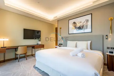a hotel room with a large bed and a desk at Elegant 3BR at The Address Residences Dubai Opera, Downtown Dubai by Deluxe Holiday Homes in Dubai