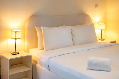 a bedroom with a white bed with two lamps at Spacious Upgraded & Elegant - 1BR in Dubai