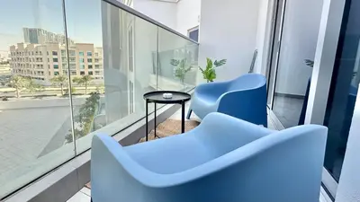 a blue chair and a table on a balcony at Spacious Luxury Studio Near Mall of the Emirates with Pool Access in Dubai
