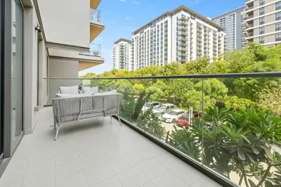 an apartment balcony with a view of a parking lot at Spacious 1BR with Pool, Gym & Kids Play Area in Dubai