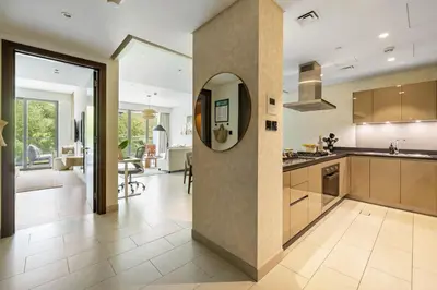 a kitchen and living room with a dining room at Spacious 1BR with Pool, Gym & Kids Play Area in Dubai
