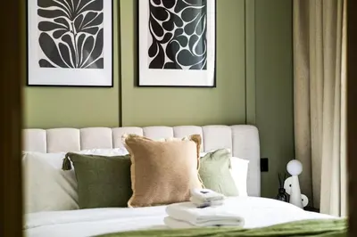 a bedroom with a white bed with green walls at New Cosy 1BR with Pool & Gym in City Centre in Dubai