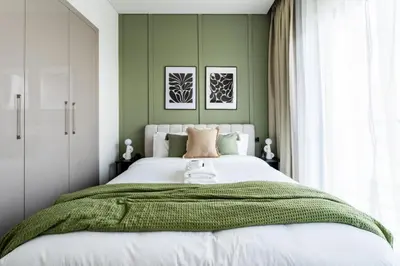 a bedroom with a large bed with green walls at New Cosy 1BR with Pool & Gym in City Centre in Dubai
