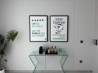 two posters on a white wall with a glass table at New Family Villa with PS5, Garden and Playroom in Dubai