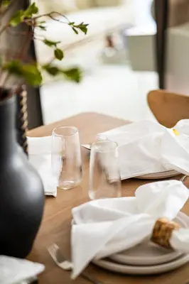 a wooden table with glasses and napkins on it at New Family Villa with PS5, Garden and Playroom in Dubai