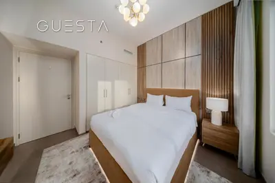 a bedroom with a large white bed and a chandelier at Park Heights 1 by Emaar, Dubai Hills Estate in Dubai