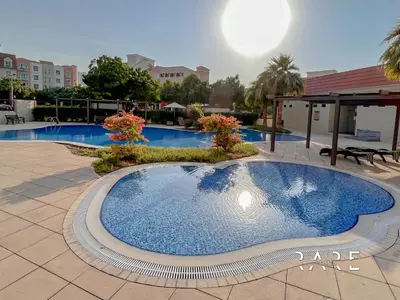 a large swimming pool in the middle of a courtyard at Rare Holiday Homes - Near Metro - Garden View - Mogul Cluster - Building# 204 - RG09 - Discovery Gardens in Dubai