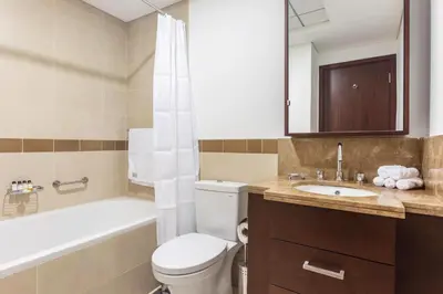 a bathroom with a toilet and a tub and a sink at Vacay lettings 1 bed close to down town Fountain View in Dubai