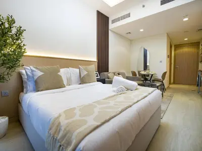 a large bed in a room with a living room at EasyGo - Bright and Airy Studio in Azizi Riviera 9 in Dubai