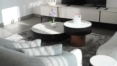 a living room with two tables and a couch at 2 Bedroom beach front apartment in Dubai