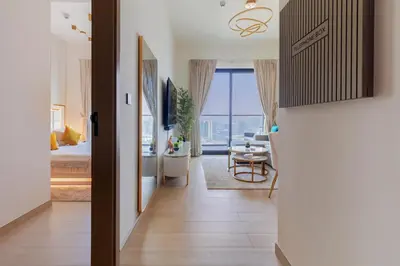 a hallway leading to a bedroom with a bed and a living room at Casa Azure in Dubai