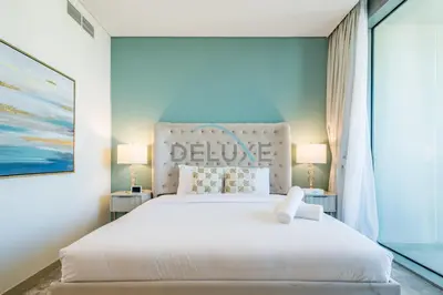 a bedroom with a large white bed with two lamps at Sea View 3BR with Assistant Room and Balcony, Just Steps from Marina Promenade, 5242 Tower 1, Dubai Marina by Deluxe Holiday Homes in Dubai